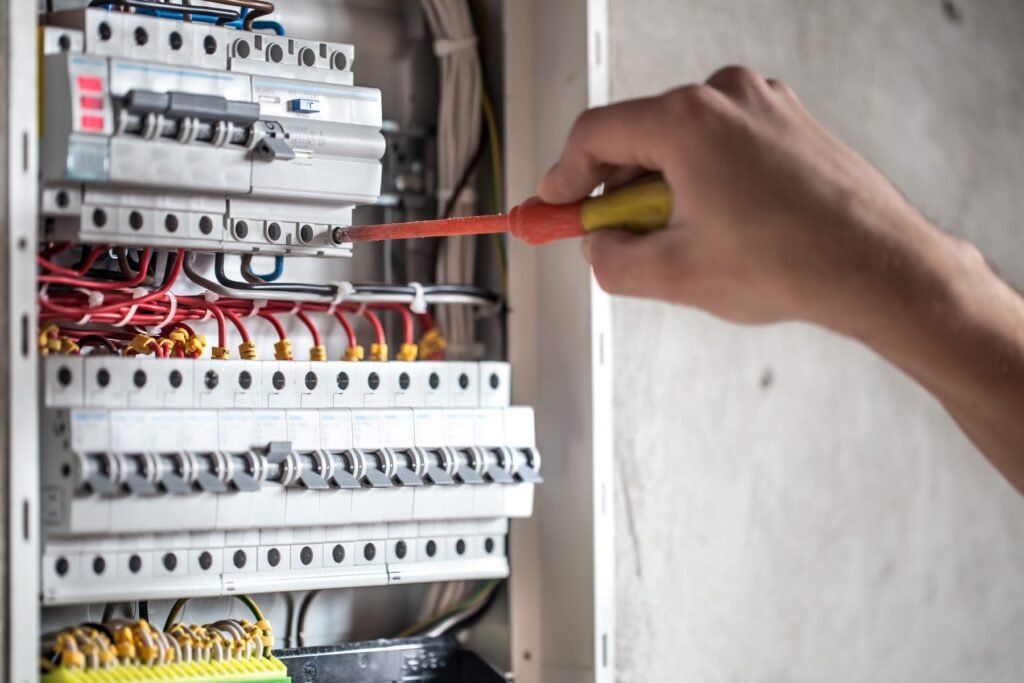Électricien raccordant un tableau électrique