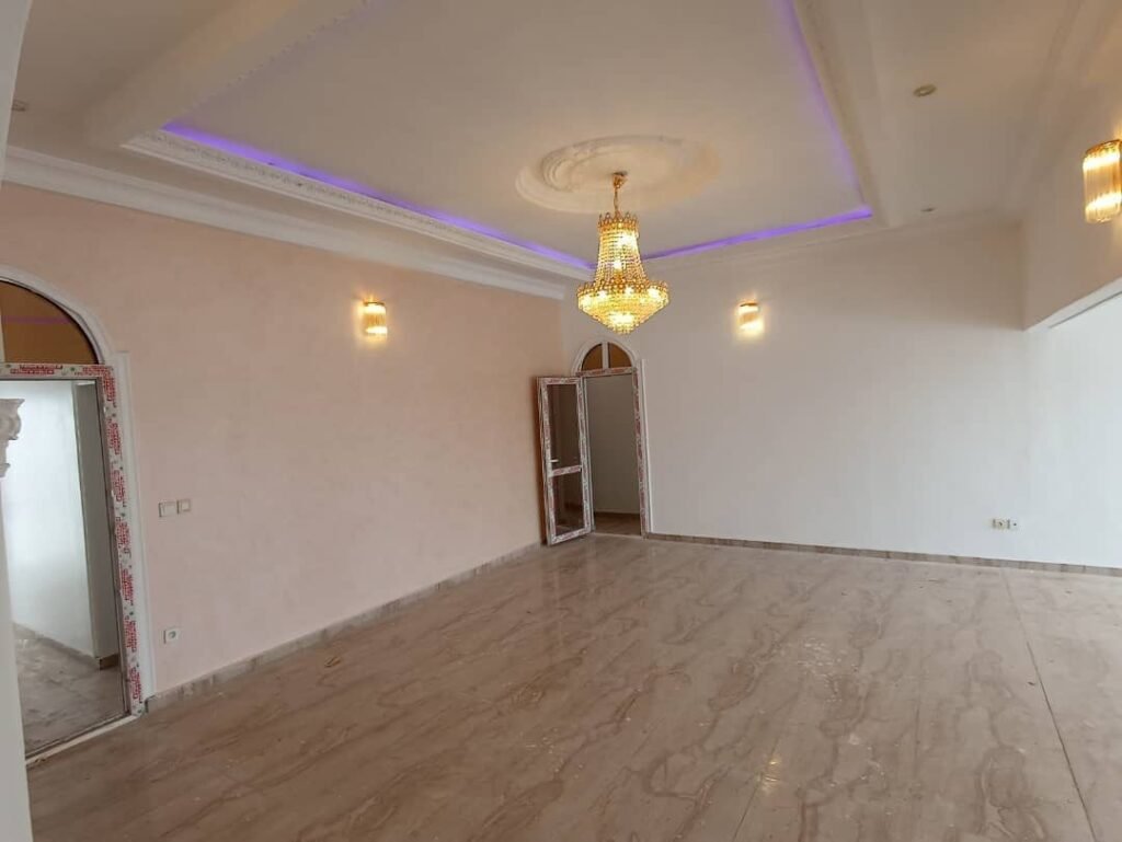 Grande salle avec lustre et sol carrelé